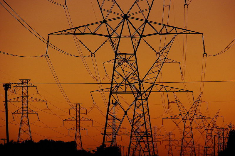 Transmission towers and power lines at sunset
